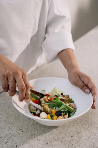 a person holding a plate of food with a salad at The Raintree, St. Mary’s Road in Chennai