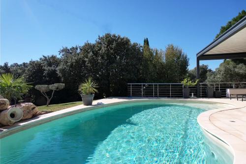 a swimming pool with blue water in a yard at very pretty contemporary villa with pool located in Aureille in the alpilles, close to the center on foot. sleeps 4. in Aureille