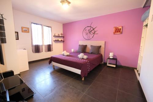 a bedroom with purple walls and a bed with pillows at very pretty contemporary villa with pool located in Aureille in the alpilles, close to the center on foot. sleeps 4. in Aureille