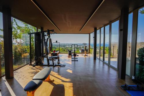 a gym with large glass windows and a gym with tread machines at Maravilla Luxury Living in Kos Town