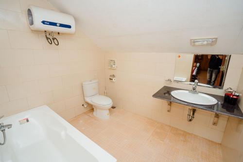 a bathroom with a toilet and a sink at Bai Tu Long Mountain Resort in Hà Cái