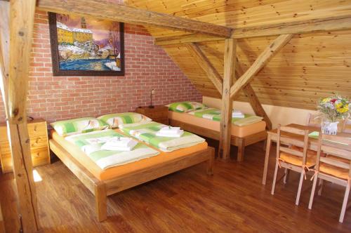 a bedroom with two beds and a table in a room at Ubytování a apartmány Sluníčko in Lomnice nad Lužnicí