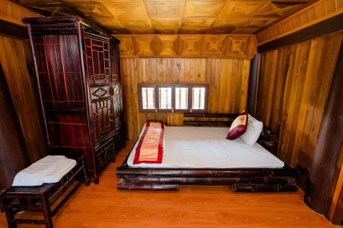 a bedroom with a bed in a wooden room at Bai Tu Long Mountain Resort in Hà Cái