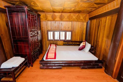 a bedroom with two beds in a wooden room at Bai Tu Long Mountain Resort in Hà Cái
