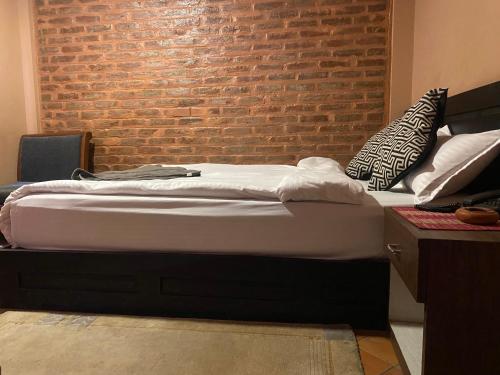 a bed in a room with a brick wall at Bhaktapur Boutique Hotel and Restaurant in Bhaktapur