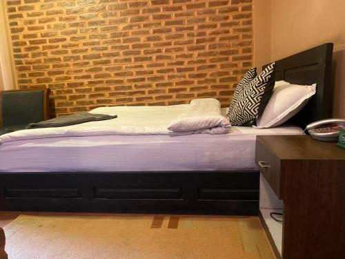 a bed in a room with a brick wall at Bhaktapur Boutique Hotel and Restaurant in Bhaktapur