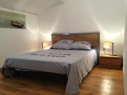 une chambre avec un lit avec deux oreillers et deux lampes dans l'établissement air-conditioned family house with fenced pool in fontvieille in the alpilles, sleeps 8, à Fontvieille