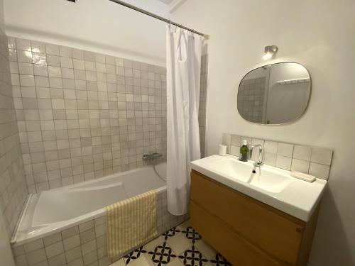 une salle de bain avec un lavabo, une baignoire et un miroir dans l'établissement Sunny apartment Garibaldi Port, FREE Private parking, à Nice