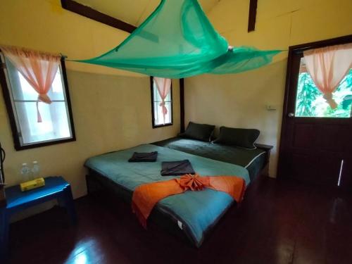 a bedroom with a bed with a tent over it at Eco Bungalow in Ko Phayam