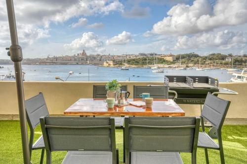 a table and chairs with a view of the water at Exclusive Seafront Townhouse Sliema, Valletta view in Sliema