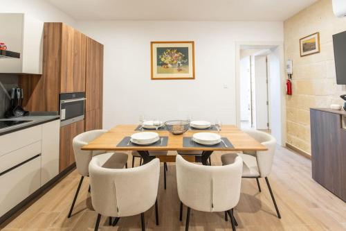 a kitchen and dining room with a wooden table and chairs at Exclusive Seafront Townhouse Sliema, Valletta view in Sliema
