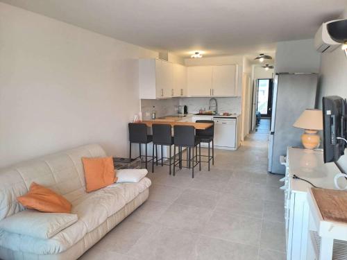 un salon avec un canapé et une cuisine dans l'établissement Marcogdu- Proche de Saint-Tropez Appartement pour 4 personnes avec vue sur la marina, à Cogolin