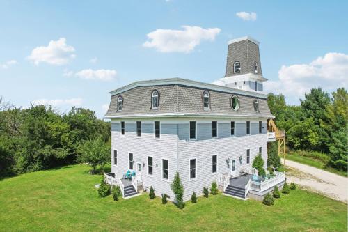 a large white house with a tower on top of a field at The Starlight Tower Manor, River, Arcades, Observatory, Theater in Fort Atkinson