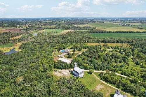 an aerial view of a house in the middle of a forest at The Starlight Tower Manor, River, Arcades, Observatory, Theater in Fort Atkinson