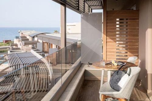 a balcony with a table and a view of the ocean at Cretan Dream Resort & Spa in Stalos