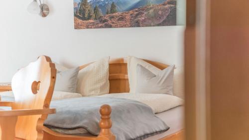 a bedroom with a wooden bed with white pillows at Haus Gleinser - Neustift im Stubaital in Neustift im Stubaital