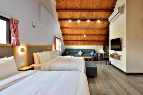 a hotel room with two beds and a couch at 大方來富莊園民宿DF Life Lodge in Yongan