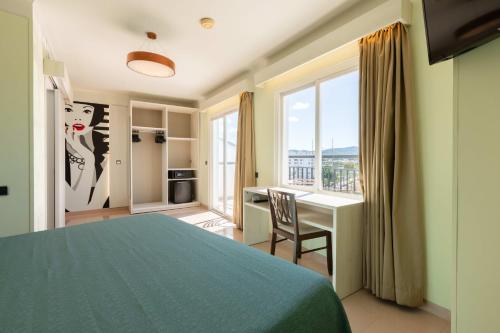 a bedroom with a bed and a desk and a window at The Red Hotel - Adults Only in San Antonio