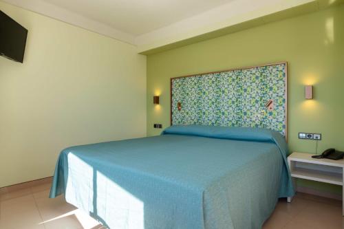 a bedroom with a bed with a blue bedspread at The Red Hotel - Adults Only in San Antonio