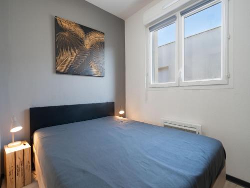 une chambre avec un lit bleu et une fenêtre dans l'établissement La Dune 75 - Villa 3P6, à Valras-Plage