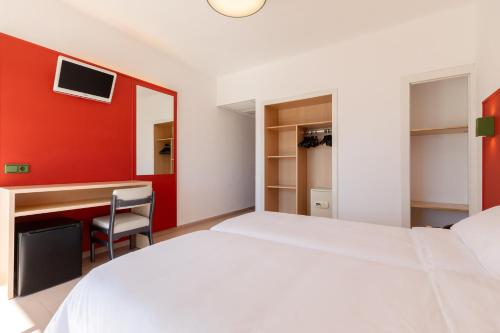 a bedroom with a white bed and a red wall at The Red Hotel - Adults Only in San Antonio