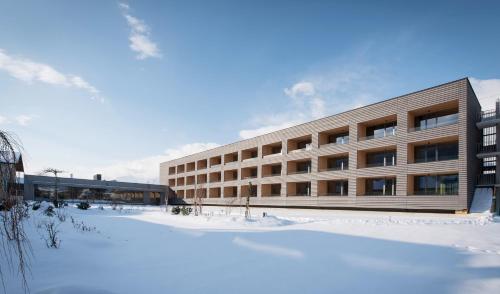 a large building with snow in front of it at Der Reschenhof in Mils bei Hall