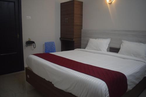 a bedroom with a large white bed with a red blanket at Golden Residency in Nāgappattinam