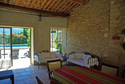 une chambre avec un lit, une table et des chaises dans l'établissement typical provencal farm 18ème in gordes, luberon area in provence with great charm with magnificent view, ideal for family or friends reunions - 12 persons, à Gordes