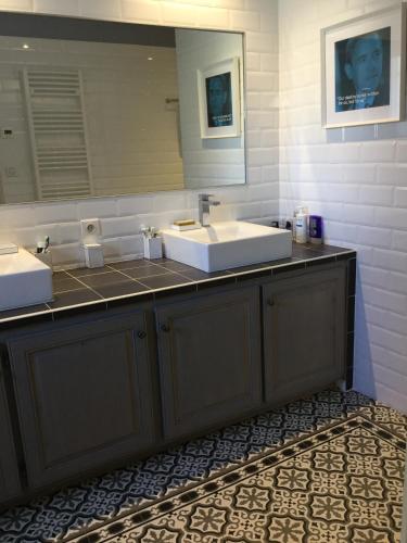 a bathroom with two sinks and a mirror at charmante location vacances avec piscine dans les alpilles, à aureille, proche du centre du village à pied- magnifique vue - 6 couchages. in Aureille