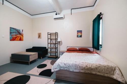 a bedroom with a large bed and a couch at Urban Haven Residence in Sanur