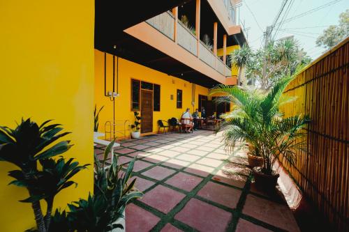 a yellow building with plants in a courtyard at Urban Haven Residence in Sanur