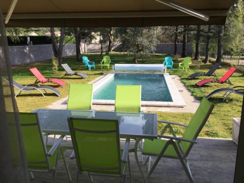 a patio with a table and chairs and a pool at A pretty family house located in a tranquil area with a pretty view of the Luberon range. in Les Taillades