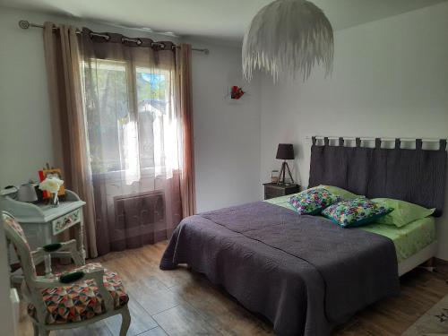 a bedroom with a bed and a chair and a window at A pretty family house located in a tranquil area with a pretty view of the Luberon range. in Les Taillades