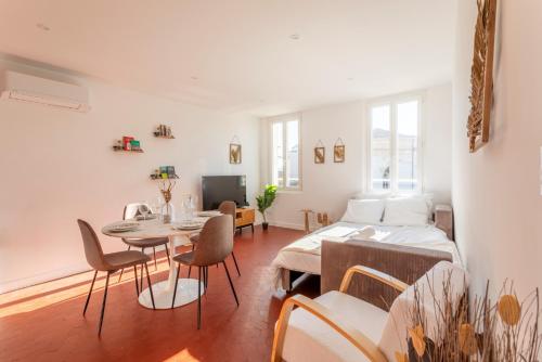 un salon avec un lit, une table et des chaises dans l'établissement Le Saint Sauveur - Centre Ville - Calme - Lumineux, à Aix-en-Provence