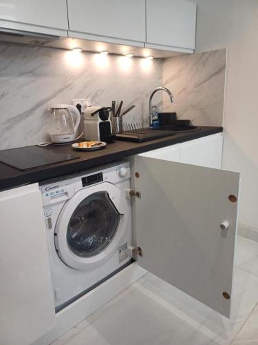 une cuisine avec une machine à laver sous un comptoir dans l'établissement Cristal Loft - Studio moderne & confort à Agen, à Agen