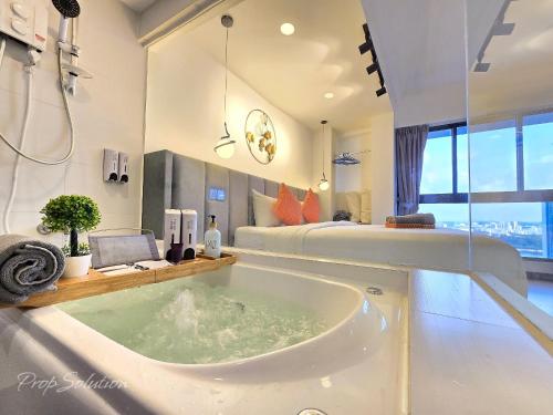 La salle de bains est pourvue d'une baignoire et d'un lit. dans l'établissement Loft Suite Seaview 2BR JB CIQ 7Pax, à Johor Bahru