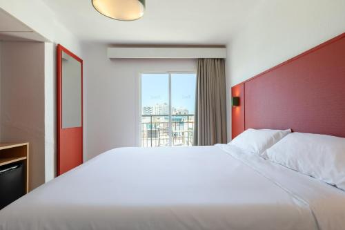 a bedroom with a large white bed with a red headboard at The Red Hotel - Adults Only in San Antonio