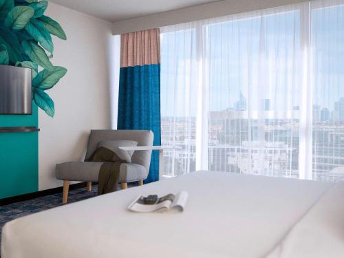 a hotel room with a bed and a chair and a window at ibis Styles Bezons Paris La Défense in Bezons