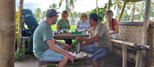 a group of people sitting at a picnic table at Rice Field inn - Lombok in Tetebatu