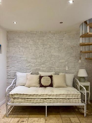 a white couch in front of a brick wall at La maison Bohème in Le Cannet