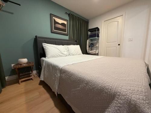 a bedroom with a bed with a white comforter at Pasadena Old Town Cottage in Pasadena