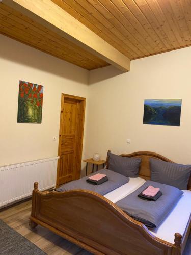 a bedroom with a large bed with a wooden ceiling at Ferienwohnung Eschbach Hof am Nürburgring in Herresbach