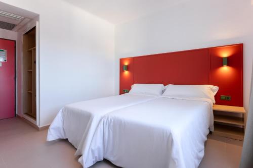 a bedroom with a large white bed with a red headboard at The Red Hotel - Adults Only in San Antonio