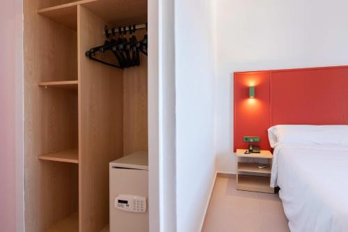 a bedroom with a white bed and a red wall at The Red Hotel - Adults Only in San Antonio