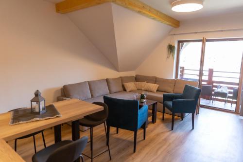 a living room with a couch and a table and chairs at Apartmán Aqua Bešeňová in Bešeňová
