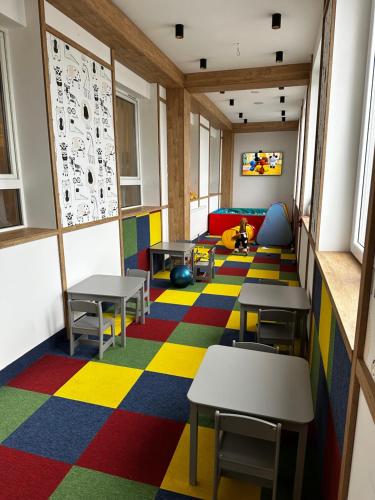 a classroom with tables and chairs on a colorful floor at WRZOS resort & wellness **** DOMKI CAŁOROCZNE in Węgierska Górka