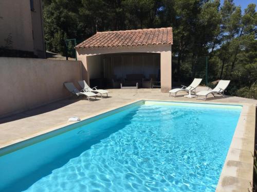 カヴァイヨンにあるpretty gite with pool in cavaillon, beautiful view on the luberon mountains, 4 people.の椅子と家のあるプール