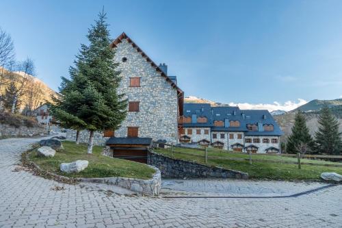 a large building with a tree in front of it at Mirador de la Neu in Pla de l'Ermita