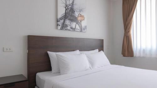 a bedroom with a bed with white sheets and a window at Pas Cher Hotel de Bangkok in Bangkok