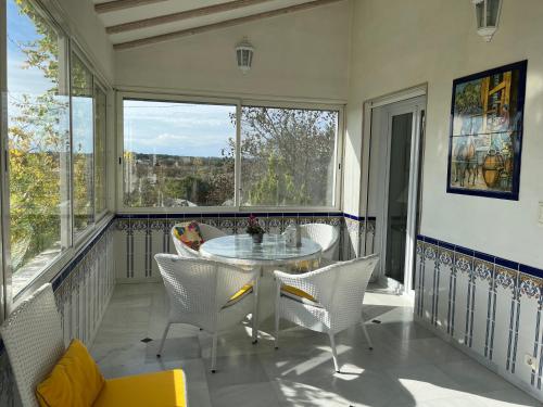 une véranda avec une table et des chaises dans l'établissement Villa climatisée avec piscine privée 8 personnes proche des plages ménage offert, à Bessan